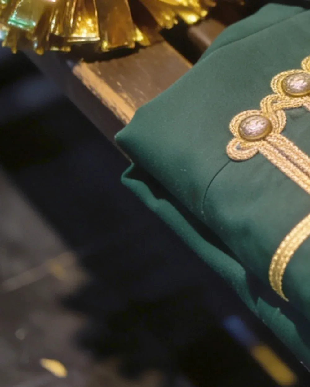 Pompons argentati appoggiati sulla divisa verde delle majorettes